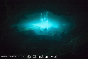 Cave divers exiting into the cavern area of a mexican Cen... by Christian Vizl 